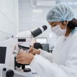 Cientista usando um microscópio para analisar amostras em um laboratório moderno.