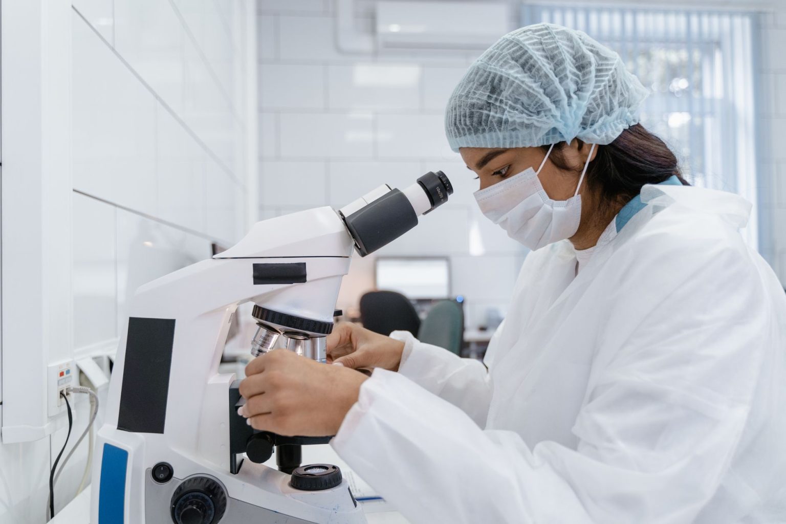 Cientista usando um microscópio para analisar amostras em um laboratório moderno.
