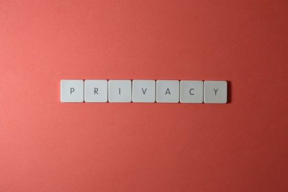 Letras formando a palavra “PRIVACY” sobre fundo vermelho, em referência à proteção de dados e à privacidade.